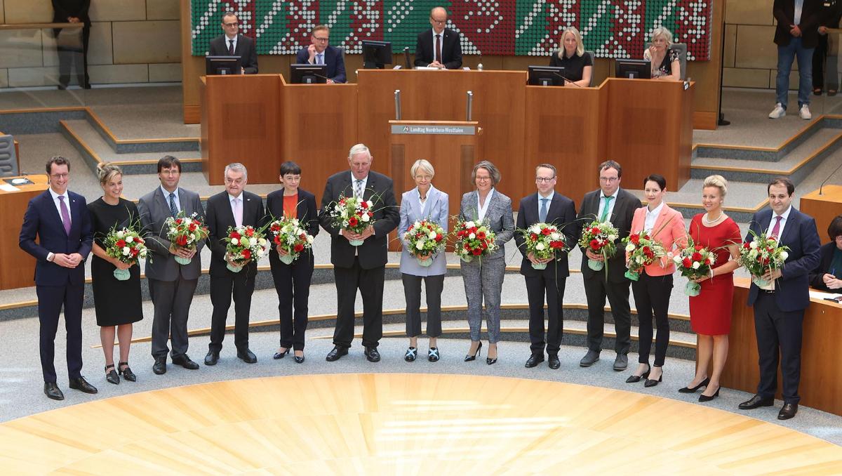 Ministerpräsident Hendrik Wüst (l.) mit den zwölf Ministerinnen und Ministern nach der Vereidigung im Plenarsaal des Landtags.